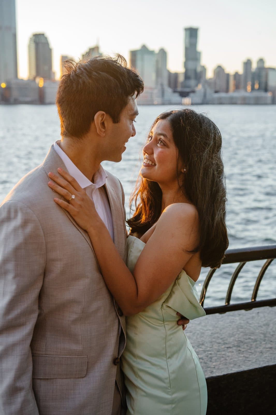 Krati and Shaan smiling at each other beside the waterfront after the proposal